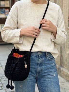 The Sak Black Crochet Bucket Crossbody Bag with Pom Drawstring